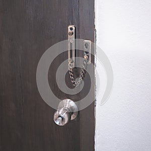 chain lock and doorknob on brown door