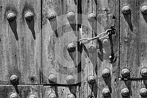 Chain lock on old wooden door with round rivets