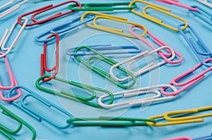 Chain made of paper clips on blue