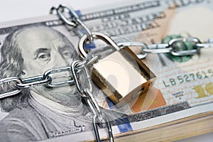 Chain and padlock around dollar bundle