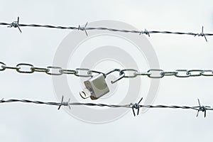 chain with padlock on barbed wire