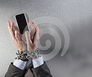 Chain tied businessman hands grabbing corporate communication phone