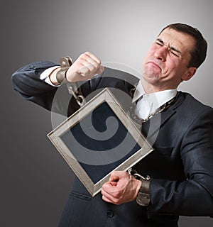 Chained businessman with a board