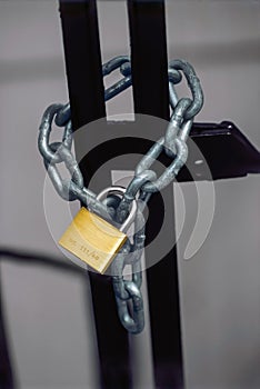 Chained gate secured by a brass padlock