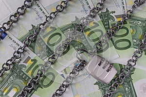Chains with combination padlock on Euro banknotes as safety bank