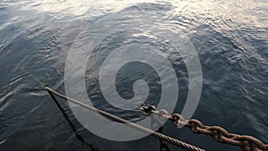 Chains and ropes on the pier going under the water