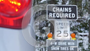 Chains or snow tires required road sign, Yosemite winter forest, California USA.