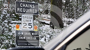 Chains or snow tires required road sign, Yosemite winter forest, California USA.