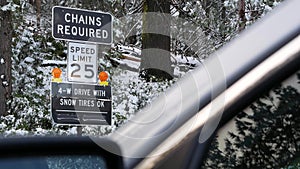 Chains or snow tires required road sign, Yosemite winter forest, California USA.