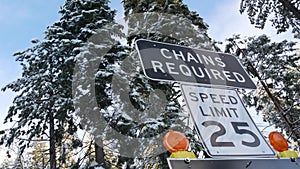 Chains or snow tires required road sign, Yosemite winter forest, California USA.