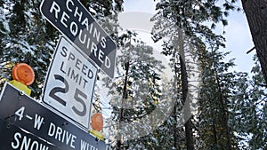 Chains or snow tires required road sign, Yosemite winter forest, California USA.