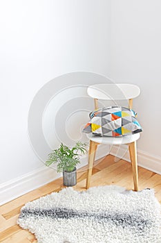 Chair with bright cushion and sheepskin rug on the floor