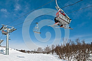 Chair lift with skiers on a blue sky