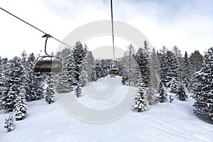 Chair lift. Through Trees Mountain Ski Resort. Beautiful day in Bellamonte ski resort. Moena, Trentino Alto Adige, Valbona, Lusia,