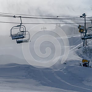 Chair lifts against artificial snow from snow guns
