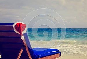 Chair lounge with red Santa hat on beach