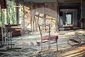 Chair and other broken furniture in the hall of abandoned school number 3 of Pripyat