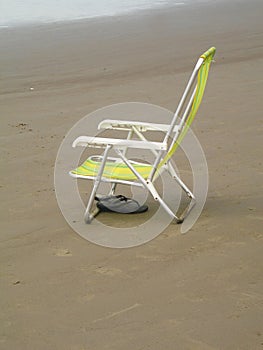 Chair sandals sand beach background Praia Grande Sao Paulo Brazil