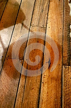 Chair shadow on rough wooden floorboards