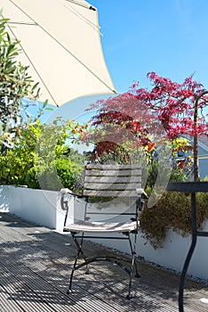 Chair and sun umbrella on a wooden terrace