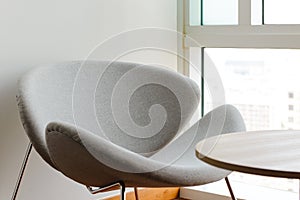 Chair and table with sunlight near window in the living room.