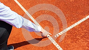 Chair umpire checking mark on clay tennis court