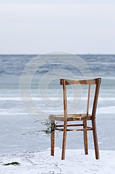 Chair washed ashore and facing the ocean