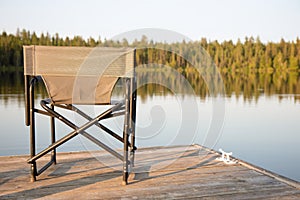 A Chair on a Wooden Dock Looking Out on a Lake in Summer