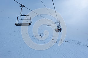 Chairlift that climbs the high mountain of the Pyrenees on a cloudy and snowy day with fog in Andorra, Grandvalira.