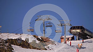 Chairlift rising skiers up along the skiing slope in the French Alps