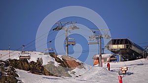 Chairlift rising skiers up along the skiing slope in the French Alps