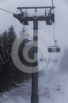 Sedačková lanovka v lyžiarskom areáli v hmle. Roháče - Spálená, Západné Tatry. Slovensko