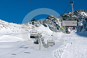 Chairlift with skierrs in high Alpine ski resort