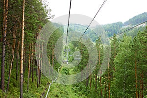 Chairlift to the top of the mountain. Beautiful summer forest landscape.