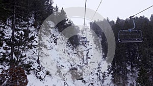 Chairlift that transports skiers to the ski slopes between snowy trees, Pyrenees, Grandvalira, Andorra.