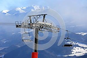 Chairlift on winter ski resort against mountain Background