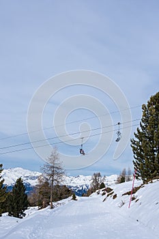 Chairlifts in winter with undefined skiers in ski resort