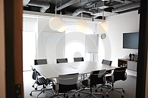 Chairs Around Boardroom Table In Empty Modern Meeting Room