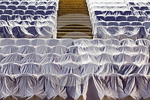 Chairs in the auditorium, covered with a white cloth to protect from dust and dirt