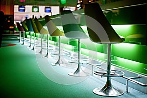 Chairs in bar with green lights