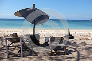 Chairs and broken umbrela at pink beach