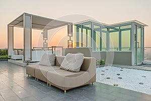 Chairs and a couch provide a place from a highrise rooftop photo