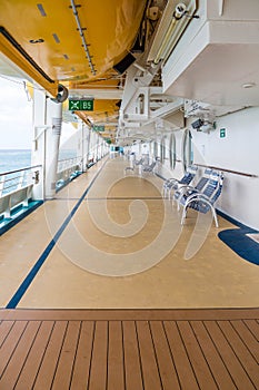Chairs on Deck of Cruise Ship Under Lifeboats