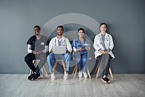 Chairs, doctors and happy team by wall for interview or public health conference and training session or meeting. People