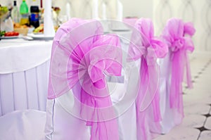 Chairs with pink bows.