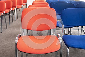 Chairs red and blue in row. Empty seats in a meeting room or auditorium. Selective focus