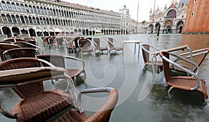 chairs and small tables of sidewalk cafe in Venice Italy with hi