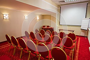 Chairs and table in conference hall with a red