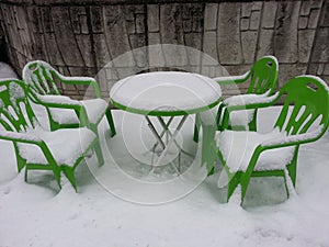 Chairs and table covered with snow