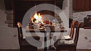 Chairs and table near fireplace, delicious meal preparation, wait for lovers couple, romantic dinner, exquisite cuisine